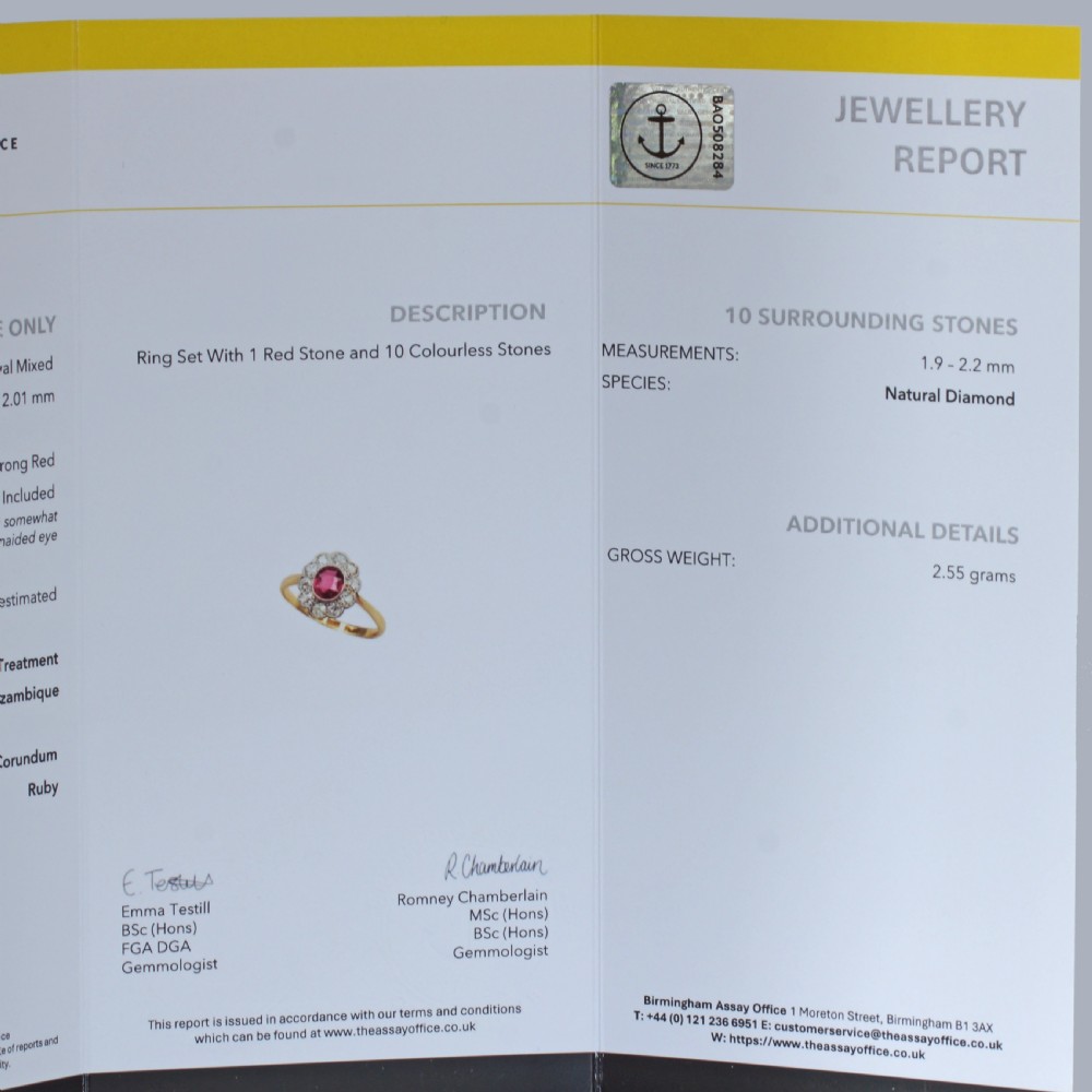 A vintage cluster ring featuring a central oval red ruby surrounded by ten round diamonds set in platinum with an 18ct yellow gold band. View XV