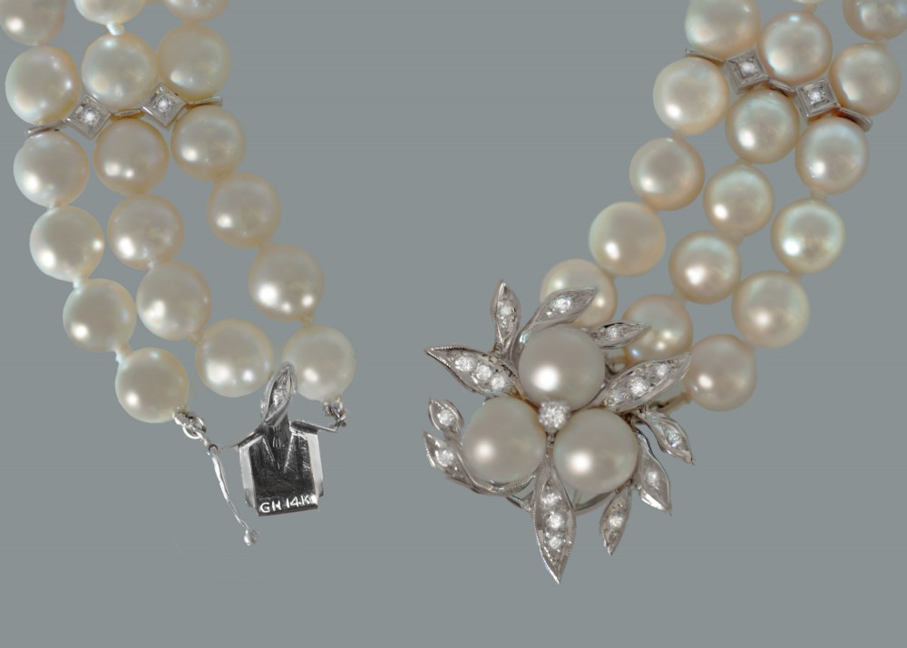 A vintage triple strand cultured pearl bracelet featuring a white gold floral clasp set with small diamonds and central pearls. View VI