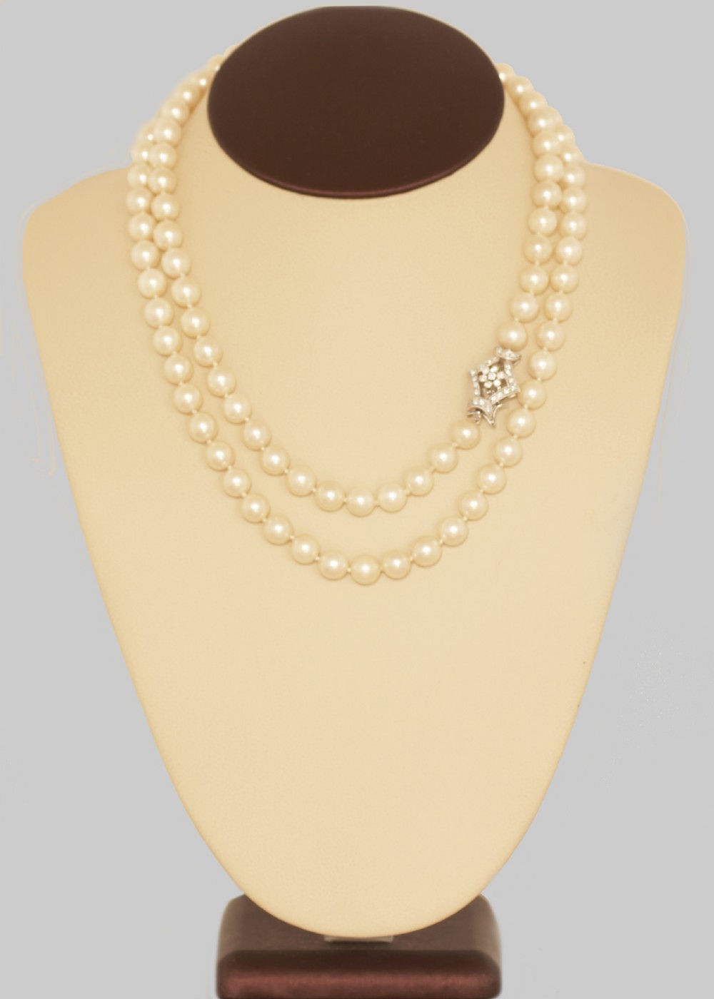 A long single strand of cream-coloured pearls fitted with a geometric 18ct white gold clasp set with diamonds. View III