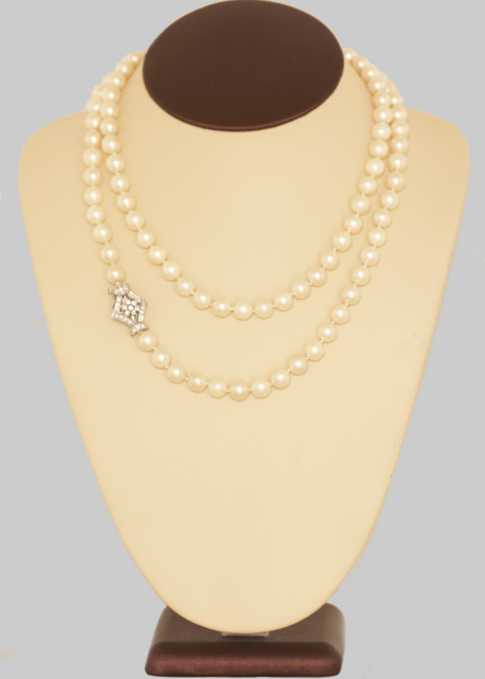A long single strand of cream-coloured pearls fitted with a geometric 18ct white gold clasp set with diamonds. View IV