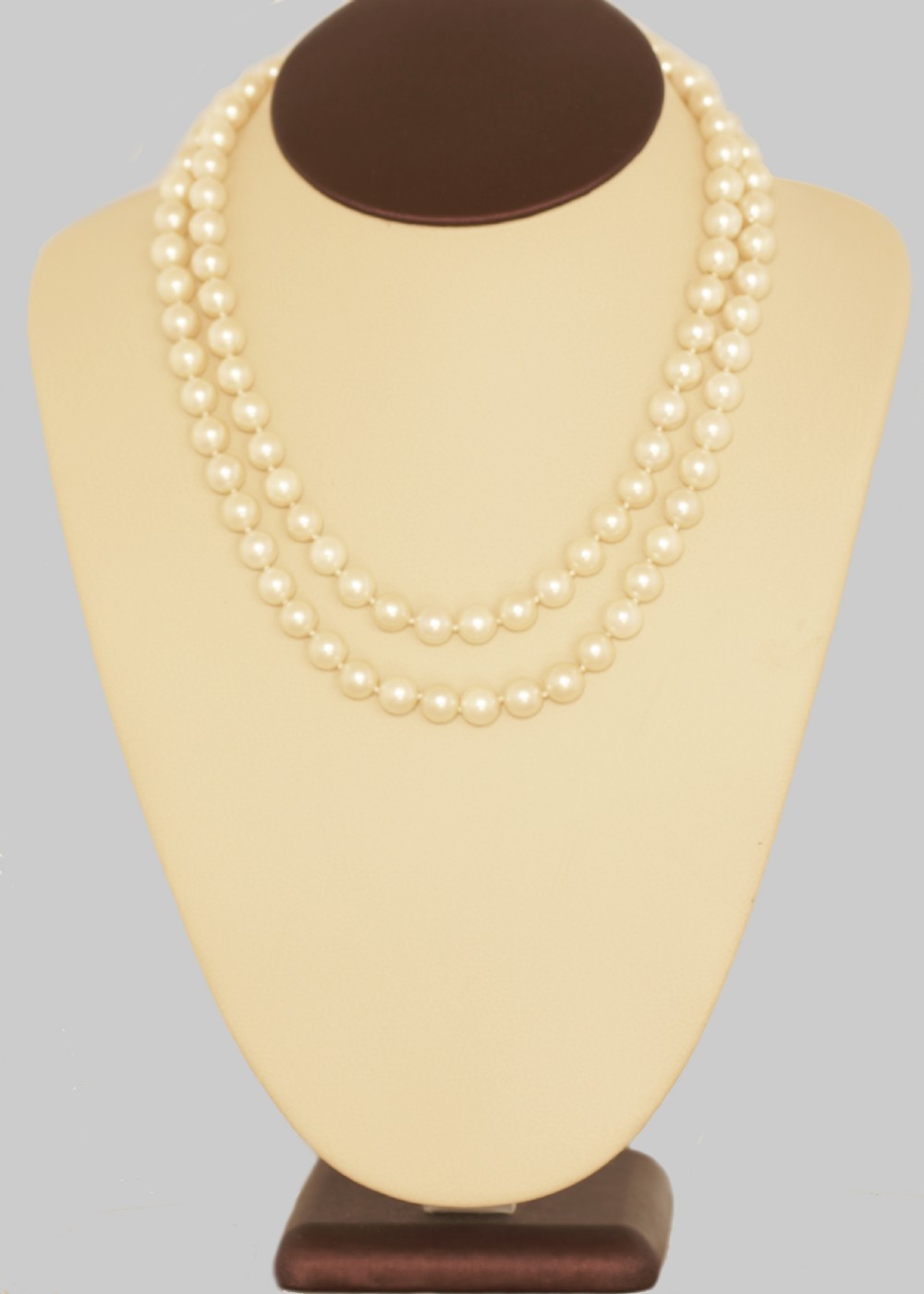 A long single strand of cream-coloured pearls fitted with a geometric 18ct white gold clasp set with diamonds. View V