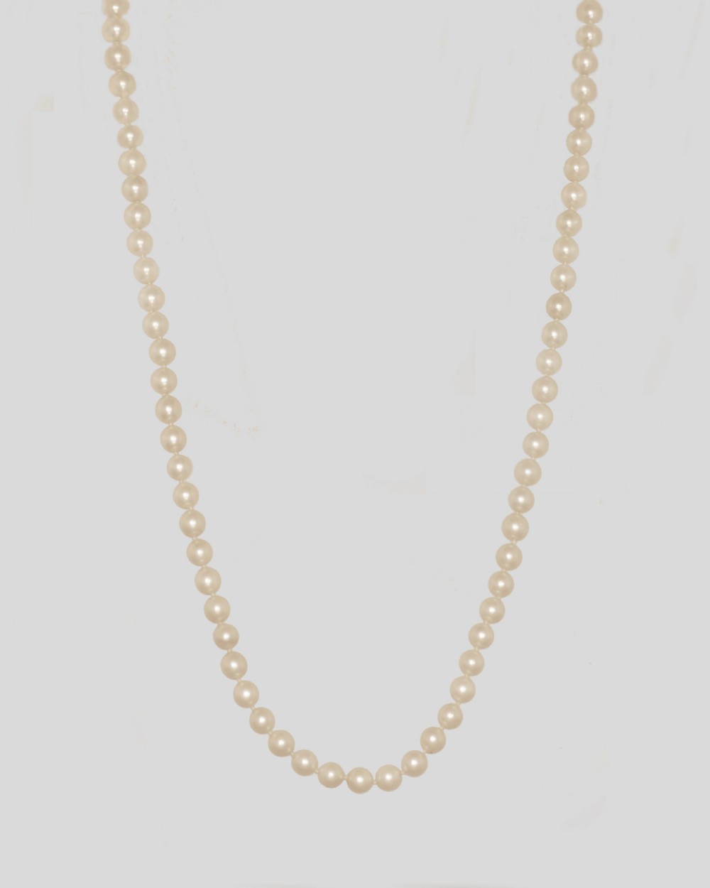 A long single strand of cream-coloured pearls fitted with a geometric 18ct white gold clasp set with diamonds. View VI