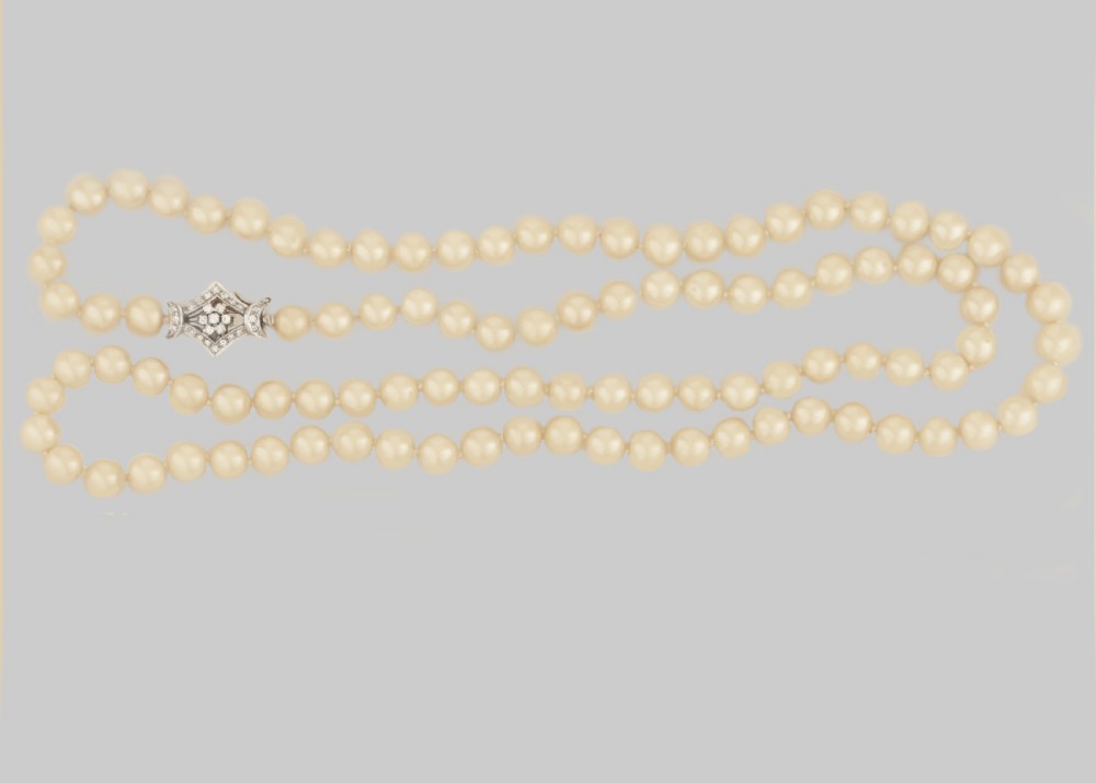 A long single strand of cream-coloured pearls fitted with a geometric 18ct white gold clasp set with diamonds. View VII