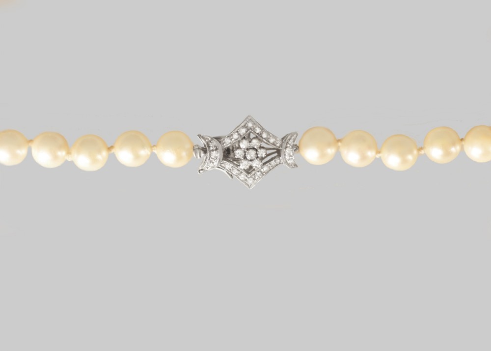 A long single strand of cream-coloured pearls fitted with a geometric 18ct white gold clasp set with diamonds. View VIII