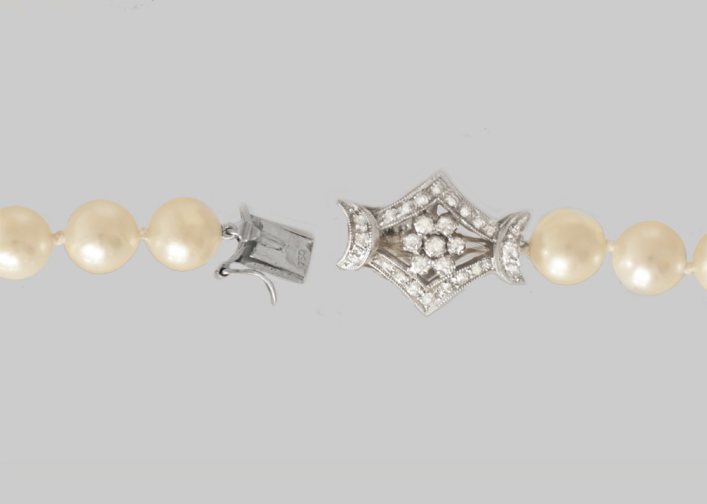 A long single strand of cream-coloured pearls fitted with a geometric 18ct white gold clasp set with diamonds. View IX