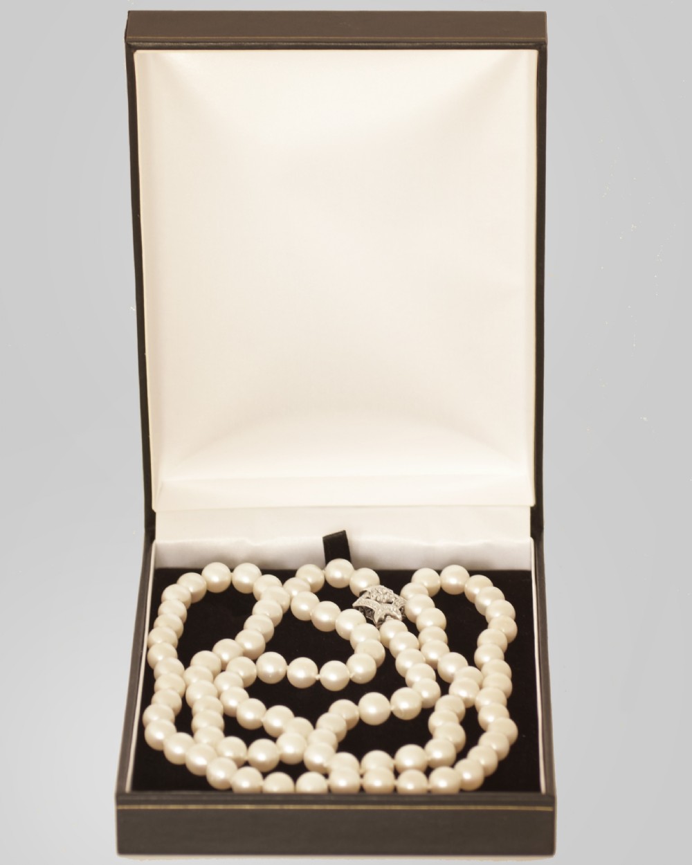 A long single strand of cream-coloured pearls fitted with a geometric 18ct white gold clasp set with diamonds. View X