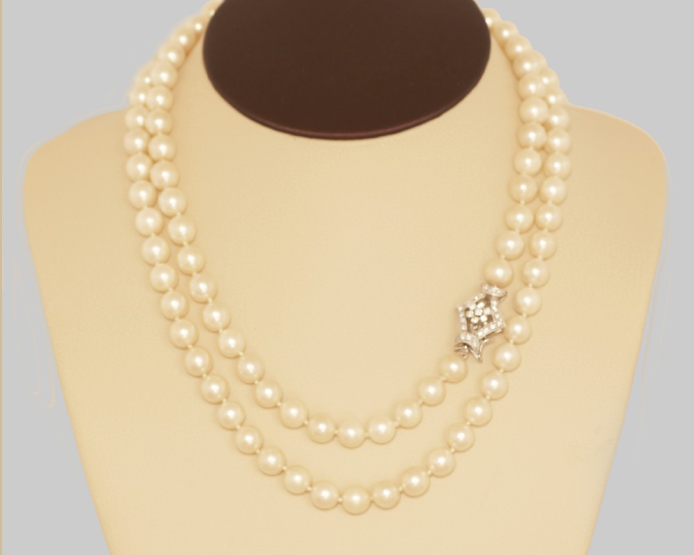 A long single strand of cream-coloured pearls fitted with a geometric 18ct white gold clasp set with diamonds. View XI
