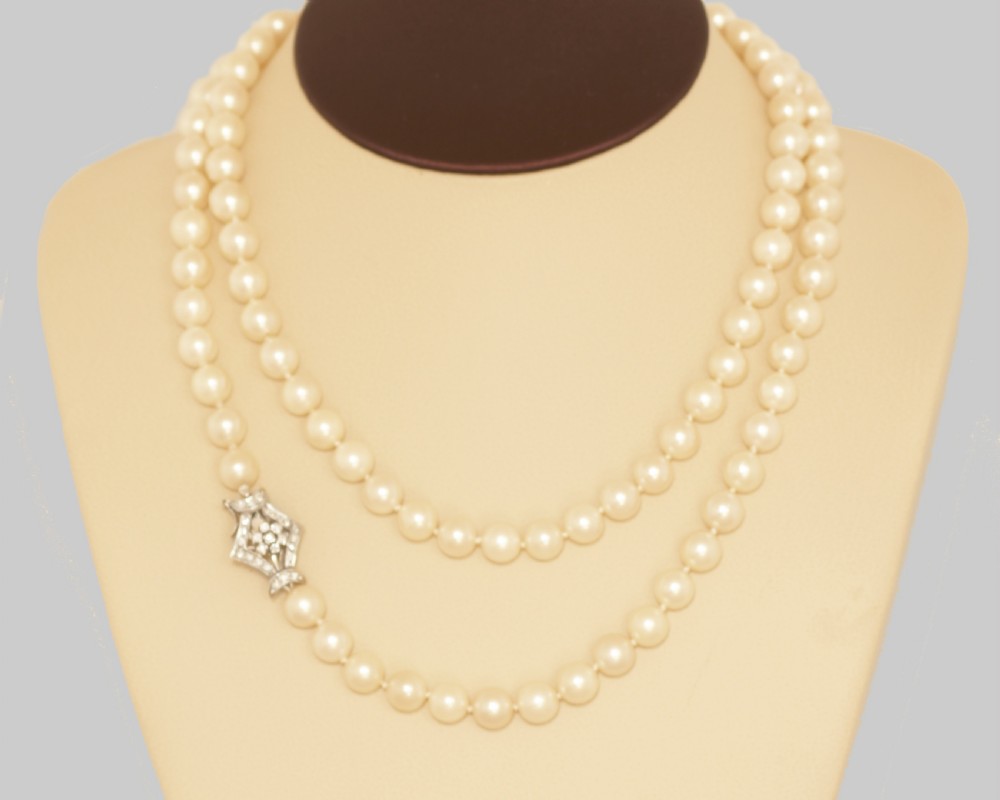 A long single strand of cream-coloured pearls fitted with a geometric 18ct white gold clasp set with diamonds. View XII