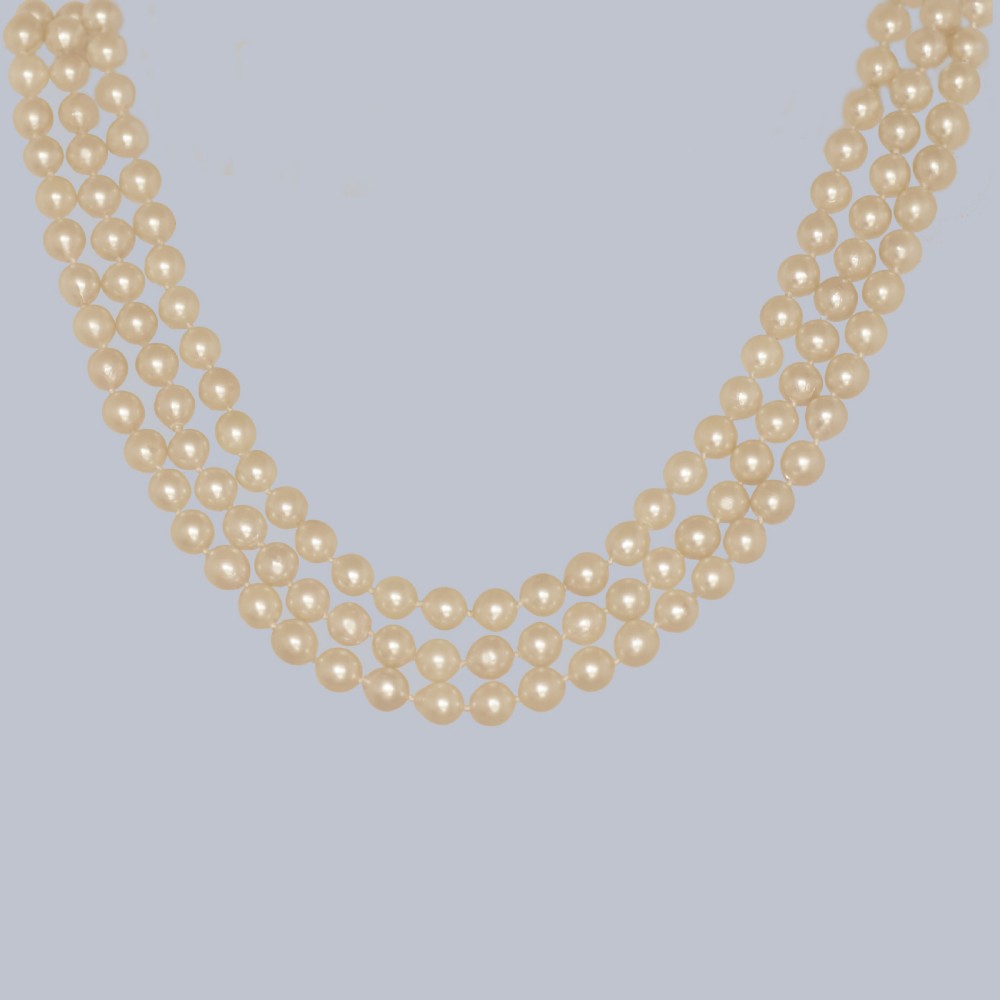 A 1960s triple strand cultured pearl necklace featuring cream-coloured pearls and a 9ct gold floral cluster clasp. View IX