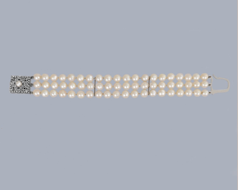 A triple strand cultured pearl bracelet featuring a rectangular sterling silver clasp decorated with marcasite stones and a central pearl. View IX