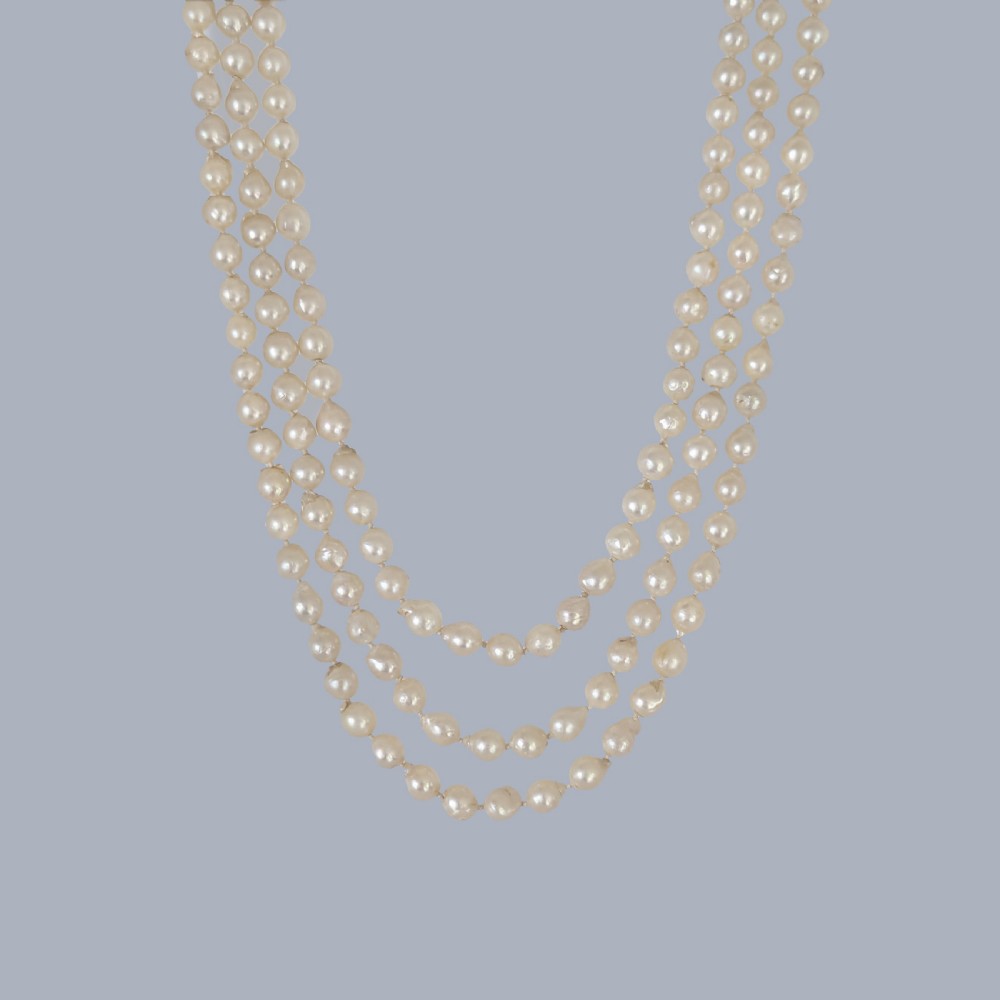 A 1920s triple strand pearl necklace featuring an Art Deco geometric clasp set with an oval green jadeite cabochon. View V