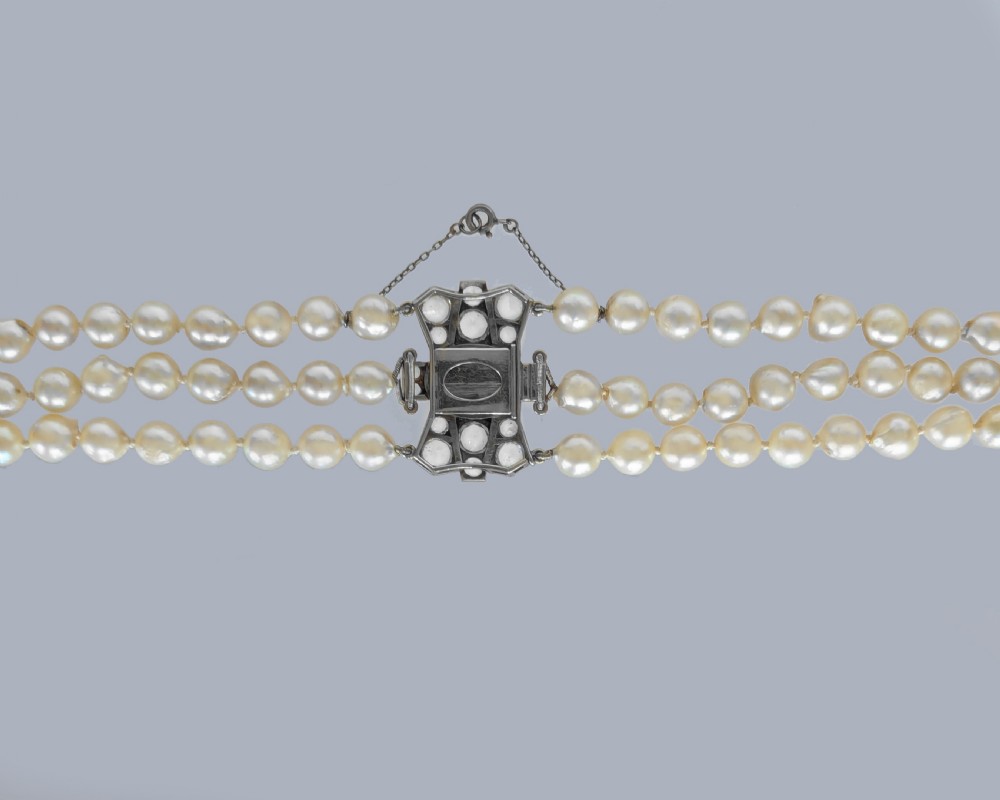 A 1920s triple strand pearl necklace featuring an Art Deco geometric clasp set with an oval green jadeite cabochon. View XI