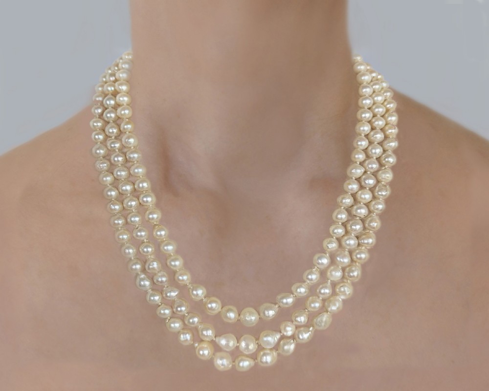 A 1920s triple strand pearl necklace featuring an Art Deco geometric clasp set with an oval green jadeite cabochon. View XII
