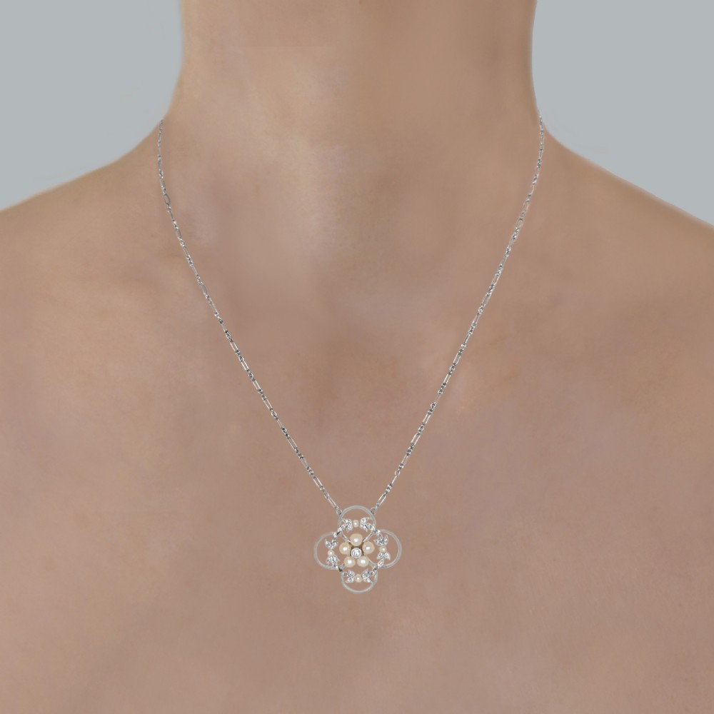 An Edwardian openwork platinum pendant featuring a central diamond encircled by pearls and leaf motifs, suspended on a fine platinum chain. View II