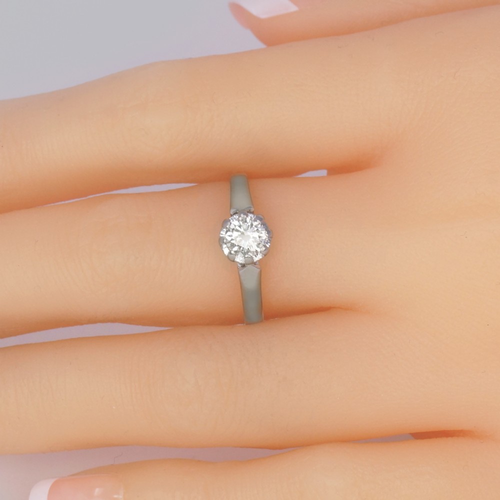 An Art Deco diamond solitaire ring featuring a round central diamond held in a platinum setting on an 18ct yellow gold band. View II