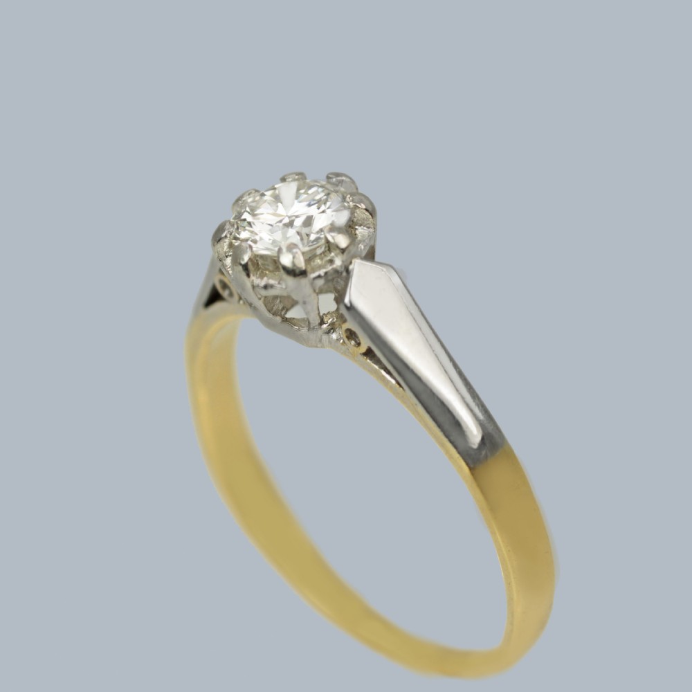 An Art Deco diamond solitaire ring featuring a round central diamond held in a platinum setting on an 18ct yellow gold band. View III