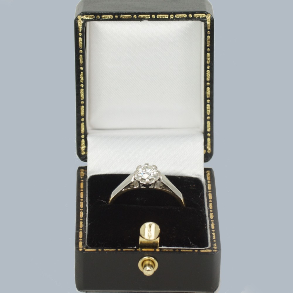 An Art Deco diamond solitaire ring featuring a round central diamond held in a platinum setting on an 18ct yellow gold band. View VI