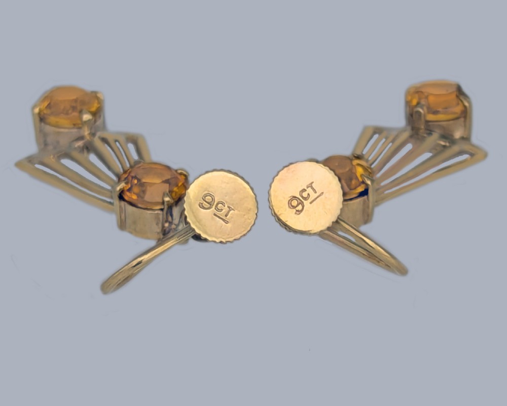 A pair of 9ct gold Art Deco drop earrings featuring round faceted yellow citrine gemstones set above and below openwork fan-shaped geometric frames. View III