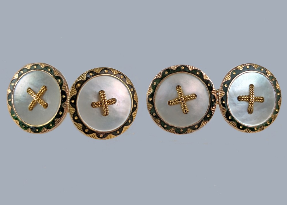 A set of four Edwardian 9ct gold cufflinks featuring circular and oval mother of pearl faces with central gold wire cross motifs and green enamel borders. View VII