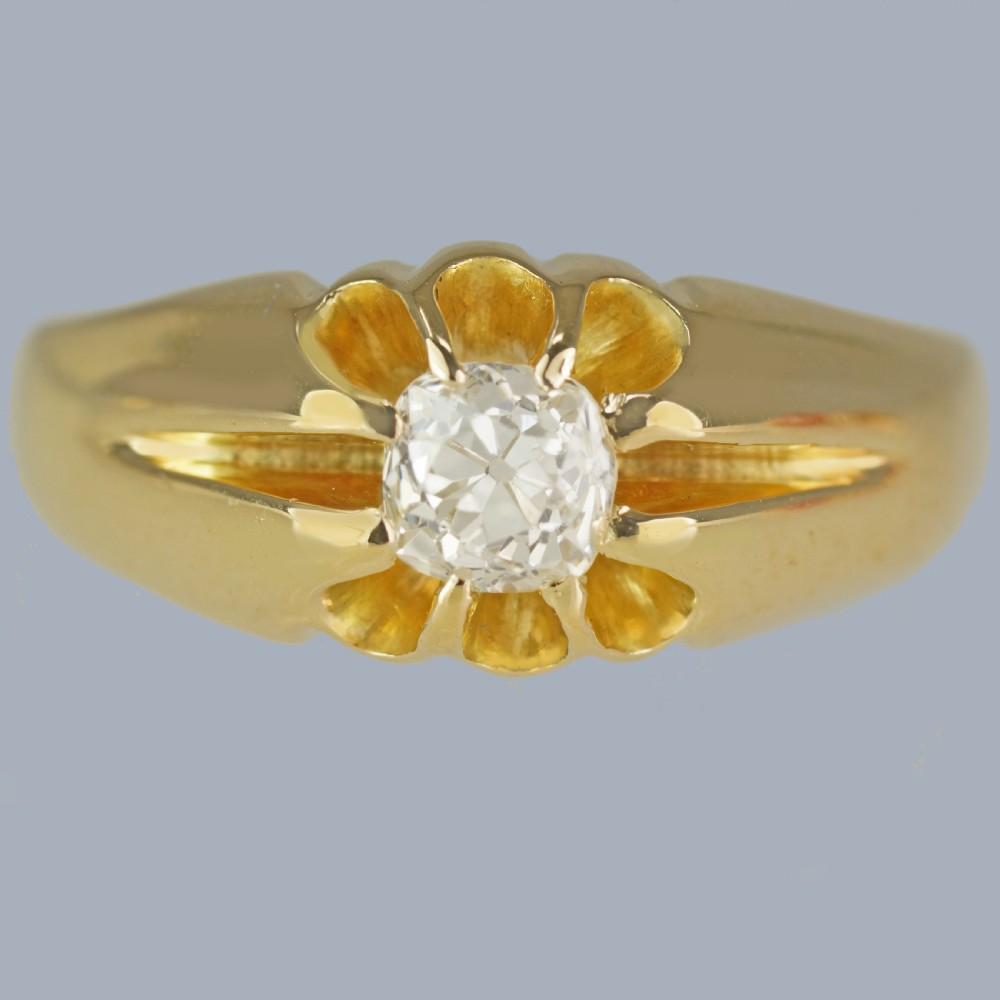 An 18ct yellow gold band featuring a central Old European cut diamond set within a fluted starburst mount.
