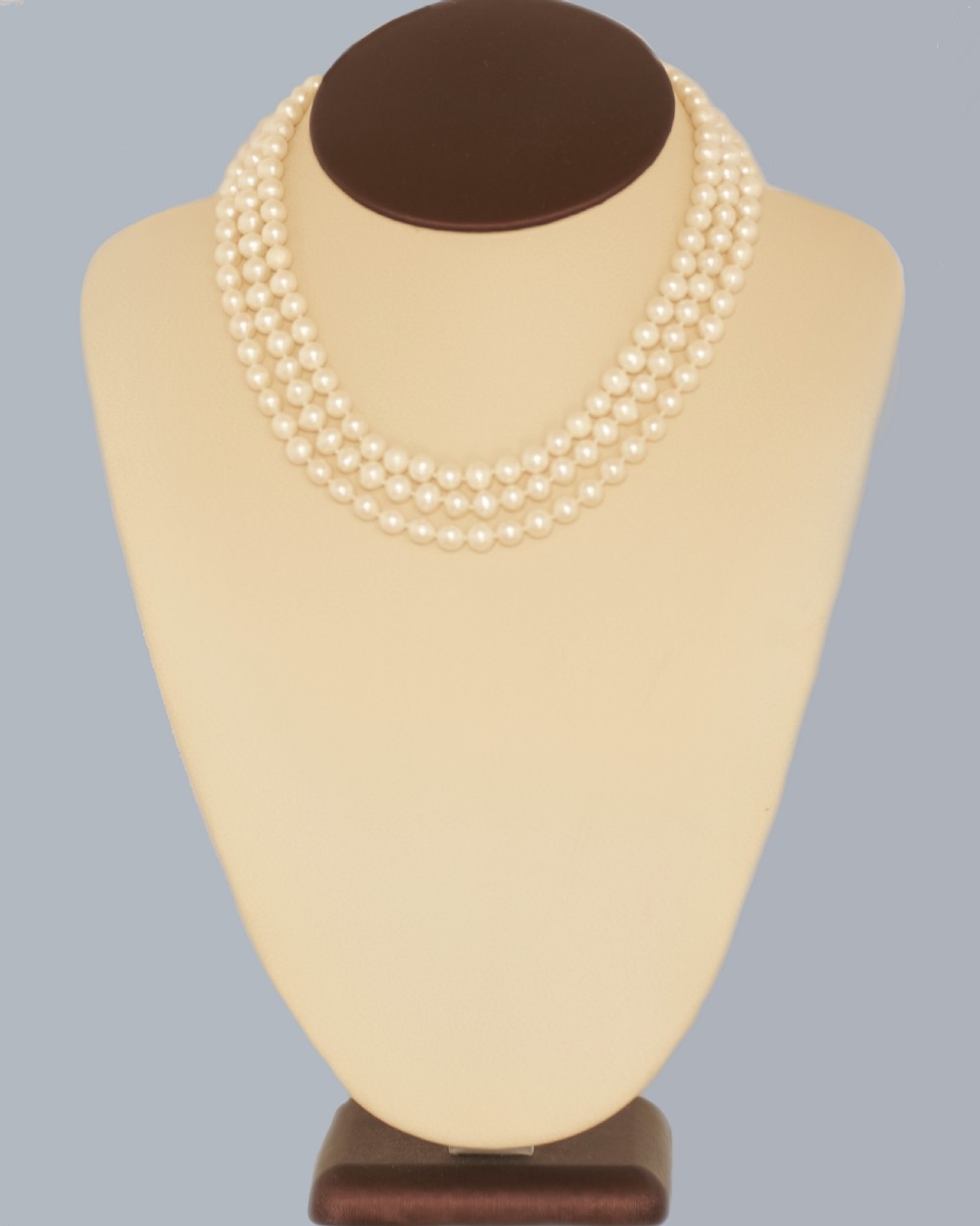 A vintage three-strand white pearl necklace joined by a silver floral clasp set with marquise-cut blue sapphires and small diamonds. View XVIII