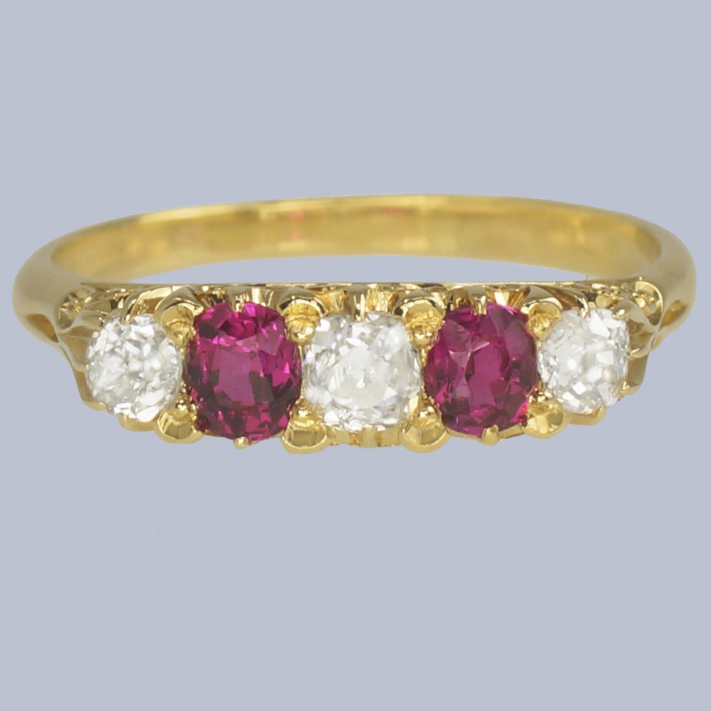 An 18ct yellow gold late Victorian five-stone ring featuring alternating oval rubies and old mine cut diamonds set in a claw gallery.