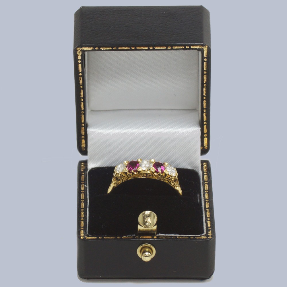 An 18ct yellow gold late Victorian five-stone ring featuring alternating oval rubies and old mine cut diamonds set in a claw gallery. View X