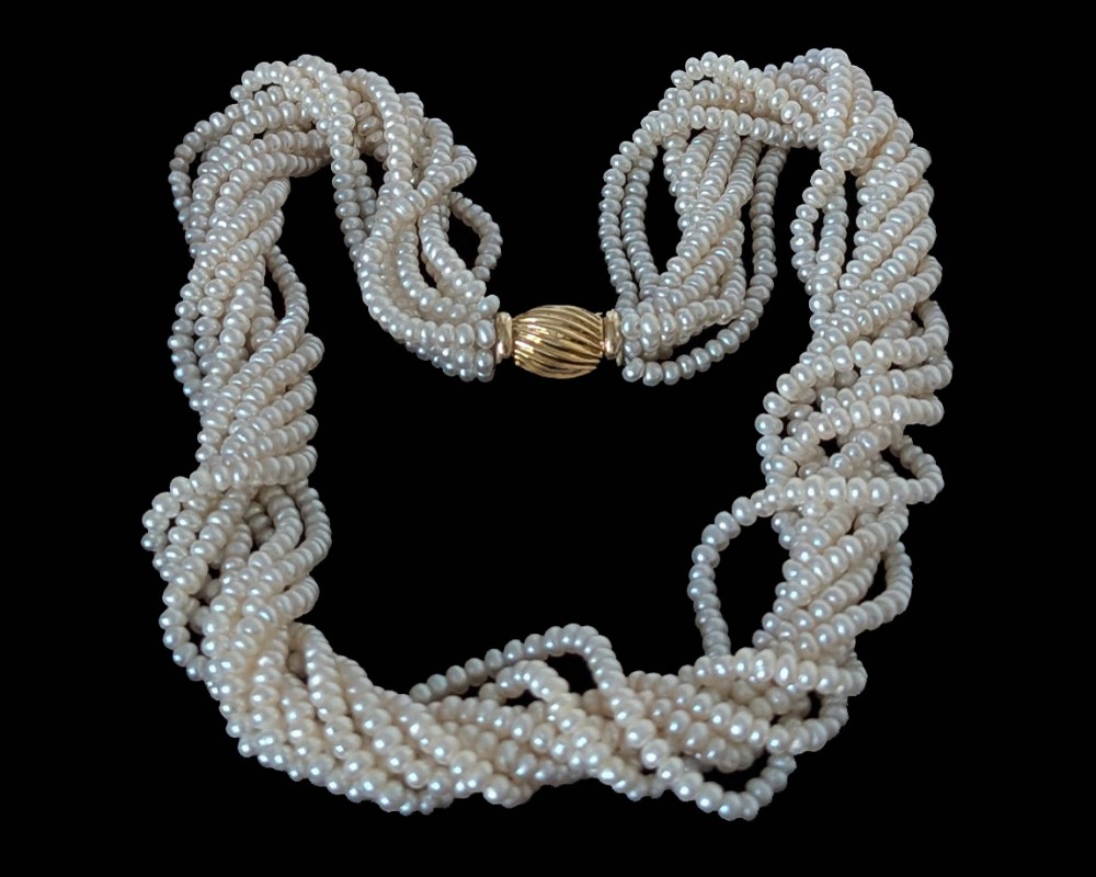An eight-strand freshwater seed pearl necklace with a fluted yellow gold barrel clasp.