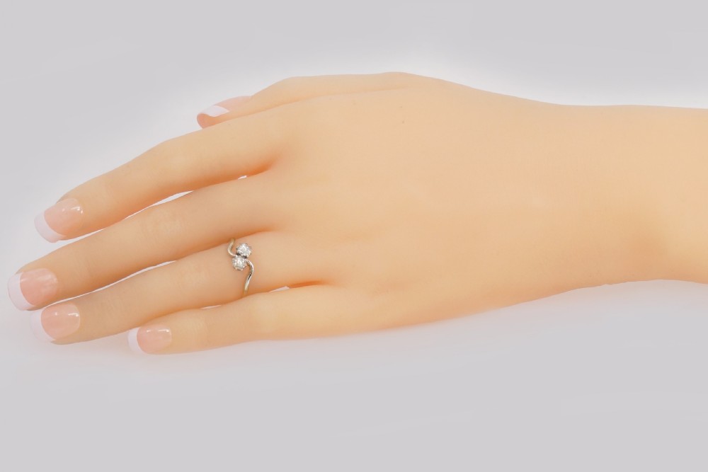 An Edwardian two-stone crossover ring featuring two old-cut diamonds set in platinum claws on an eighteen-carat yellow gold band. View VI