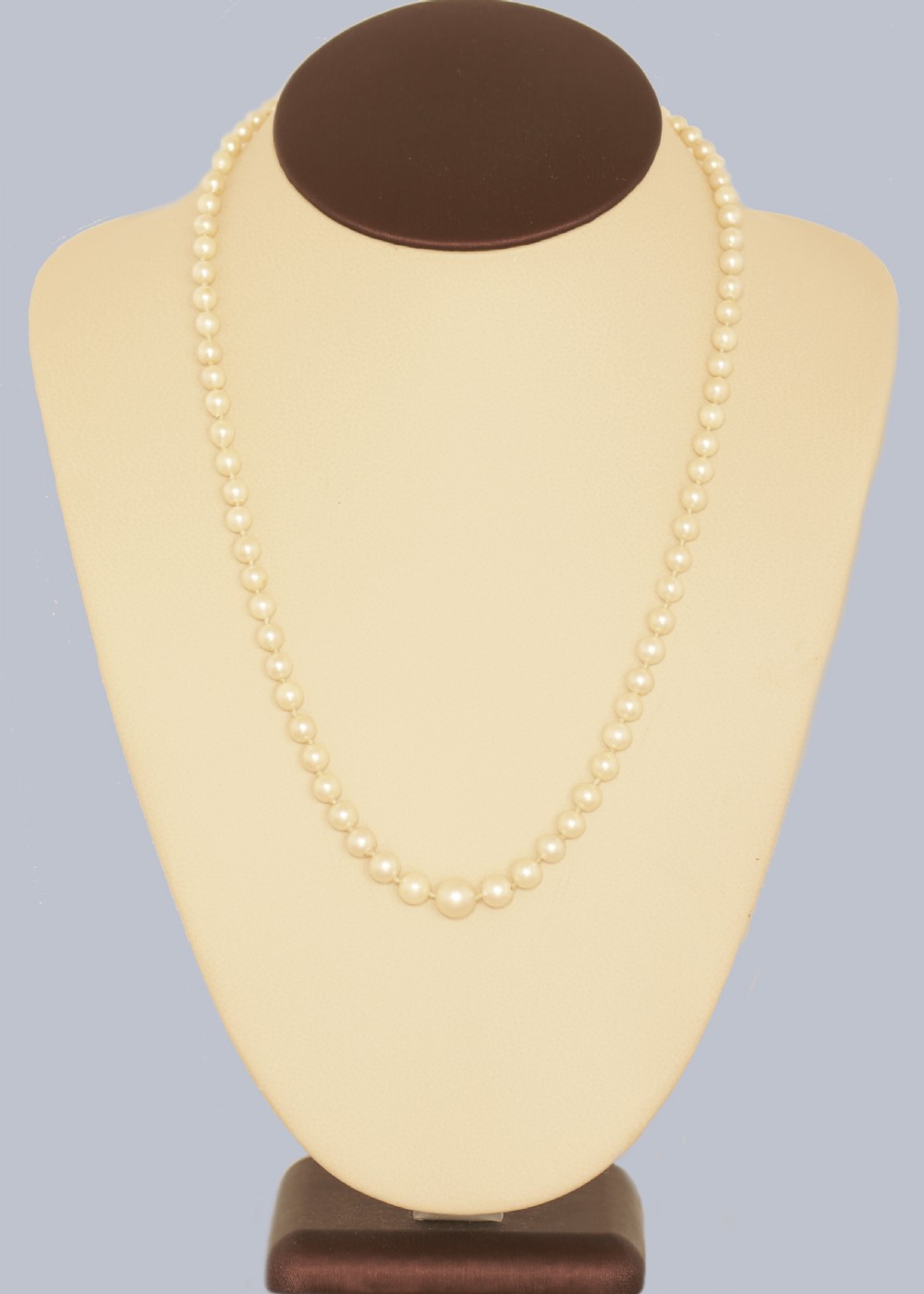 A single strand of cream cultured pearls featuring an oval purple amethyst mounted in a 9ct gold clasp surrounded by small pearls. View II
