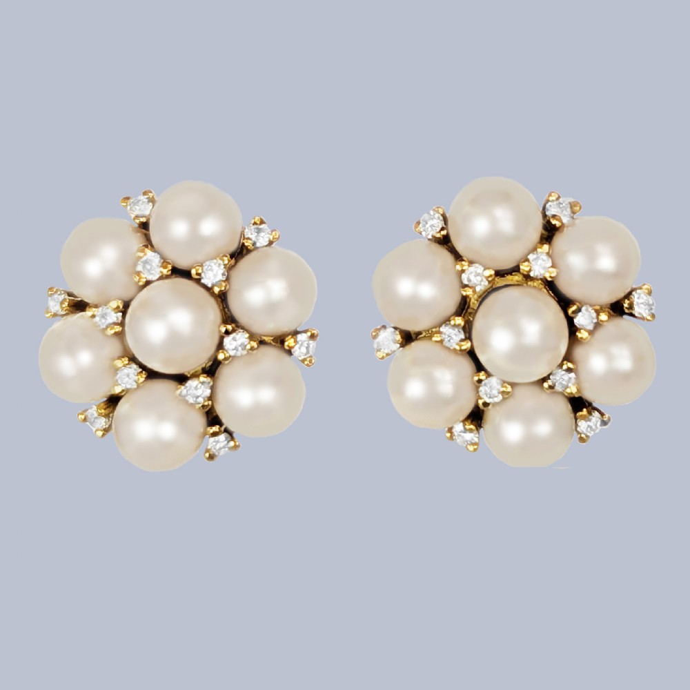 A pair of 1960s 18ct gold flowerhead cluster earrings set with central and surrounding cream pearls interspersed with diamond accents.