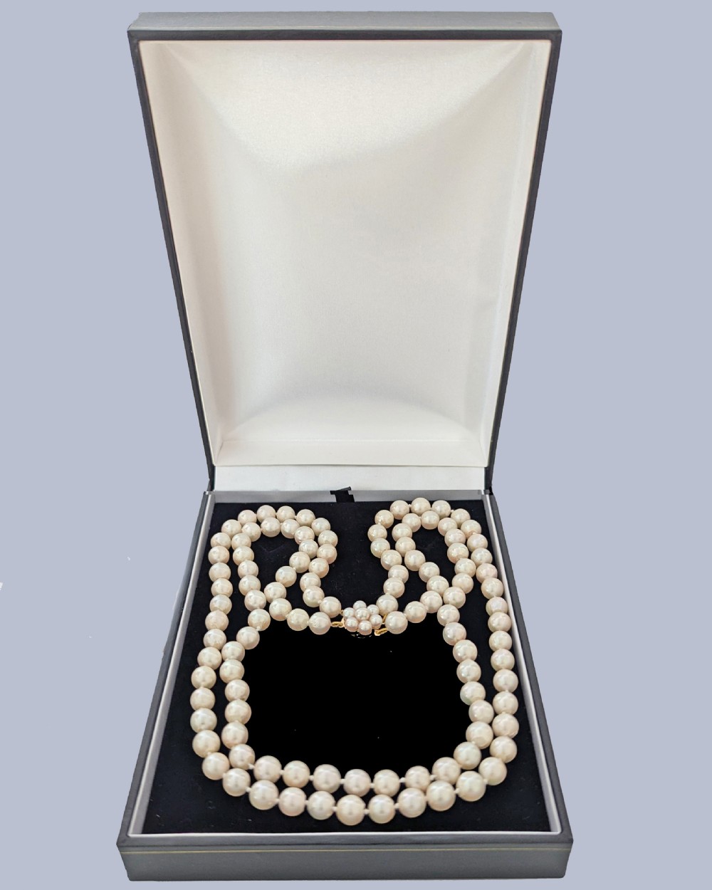 A double-strand cultured pearl necklace featuring uniform cream pearls fastened with a floral cluster gold clasp. View VII