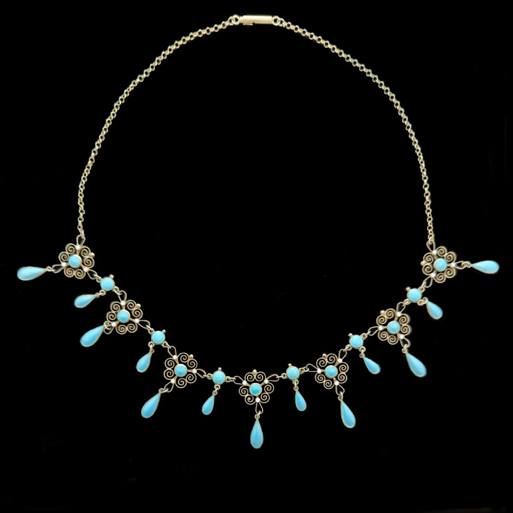 An Art Nouveau silver gilt festoon necklace featuring filigree scrollwork, turquoise guilloche enamel discs, and suspended teardrop pendants. View IX