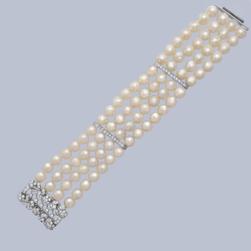 An Edwardian four-strand pearl bracelet featuring a central openwork diamond floral clasp in white metal. View VII