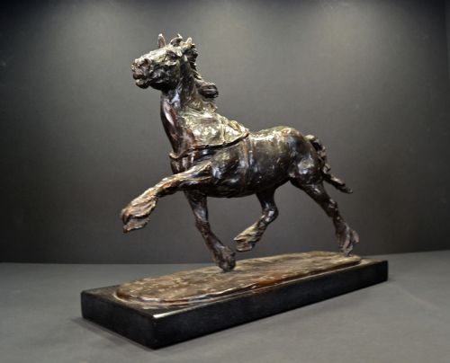 fig 1. A dark bronze sculpture of a trotting cob horse mounted on a rectangular black stone base.