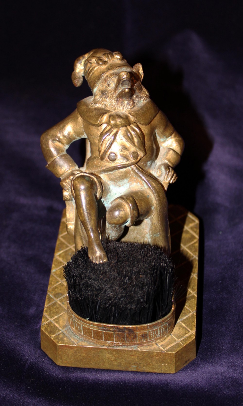 An antique gilt bronze desk accessory depicting an anthropomorphic fox wearing a nightgown and nightcap seated in an armchair with his foot resting on a bristle pen wiper. View V