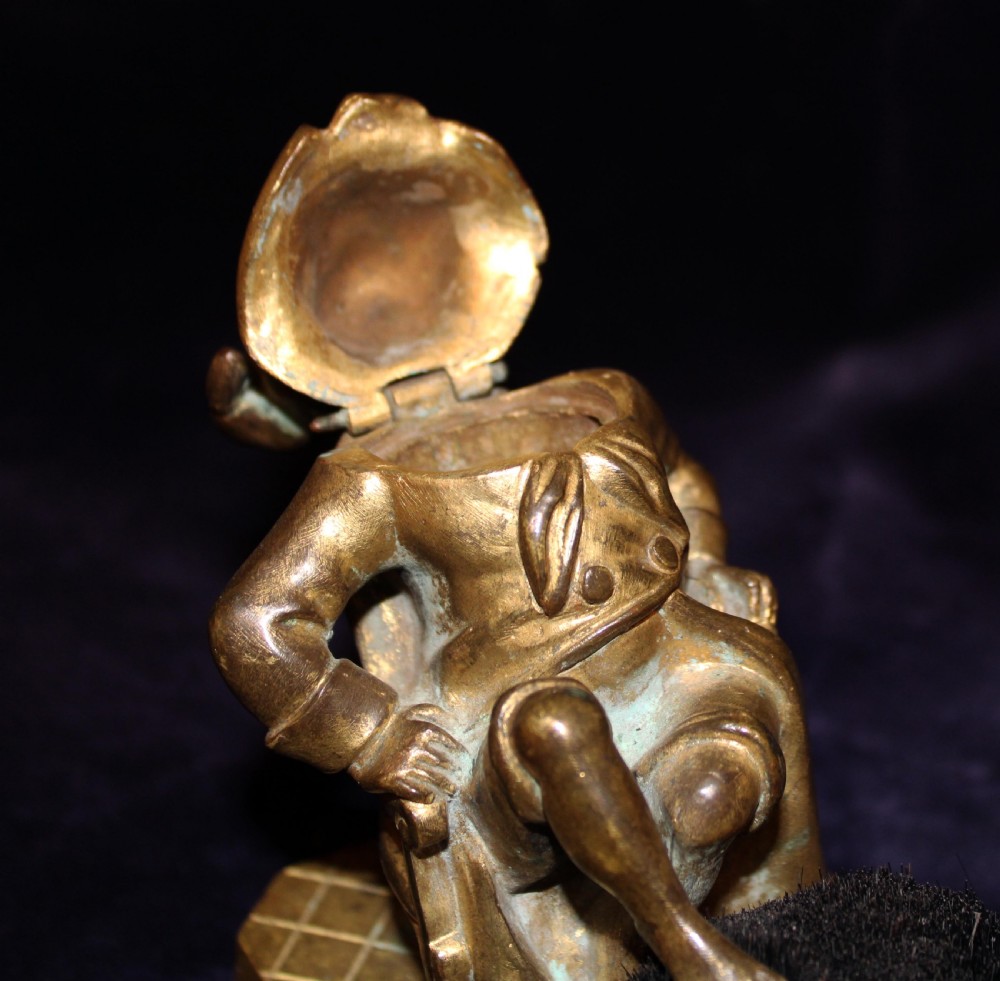 An antique gilt bronze desk accessory depicting an anthropomorphic fox wearing a nightgown and nightcap seated in an armchair with his foot resting on a bristle pen wiper. View VI