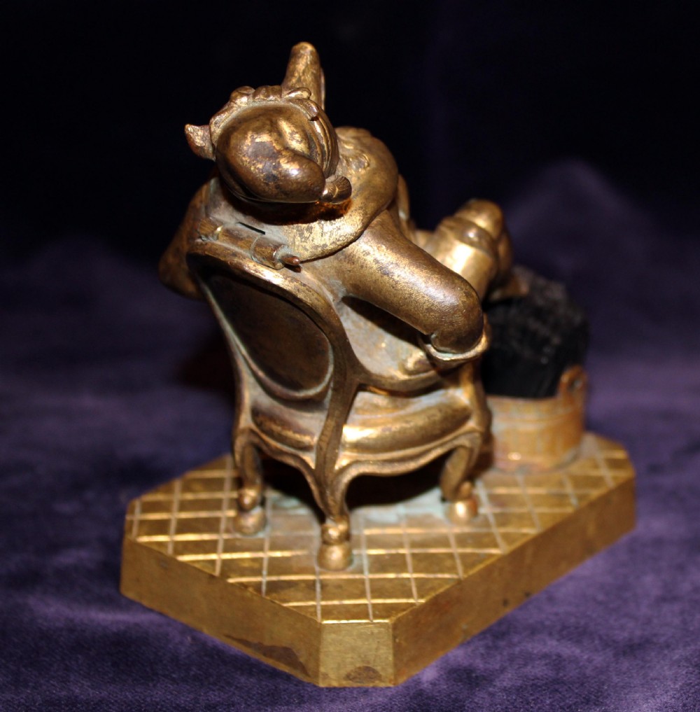 An antique gilt bronze desk accessory depicting an anthropomorphic fox wearing a nightgown and nightcap seated in an armchair with his foot resting on a bristle pen wiper. View VII