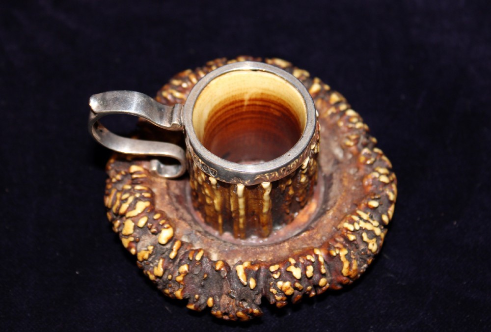 An antique chamberstick crafted from textured brown deer antler with a fitted silver rim and loop handle. View II