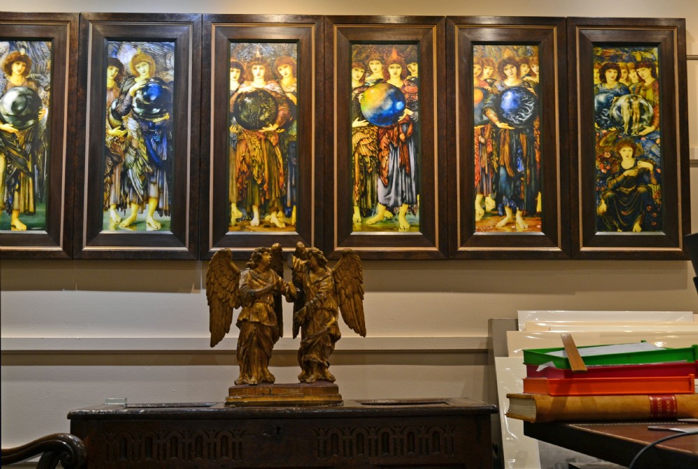 Two antique carved wooden figures of archangels with large wings, finished in distressed gold leaf and standing on a red-painted rectangular base. View IV