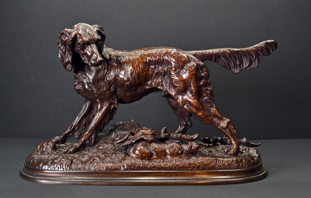 A dark brown patinated bronze sculpture depicting a setter dog standing over a rabbit on a textured ground base.