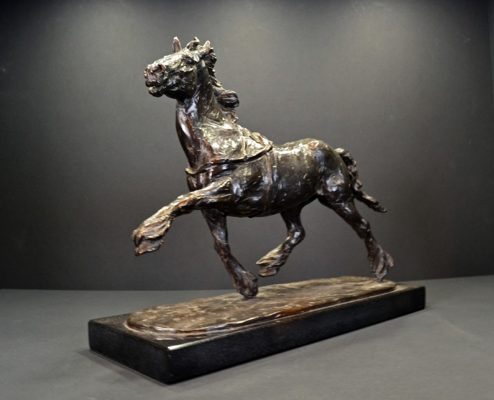 A dark bronze sculpture of a trotting cob horse mounted on a rectangular black stone base. View II