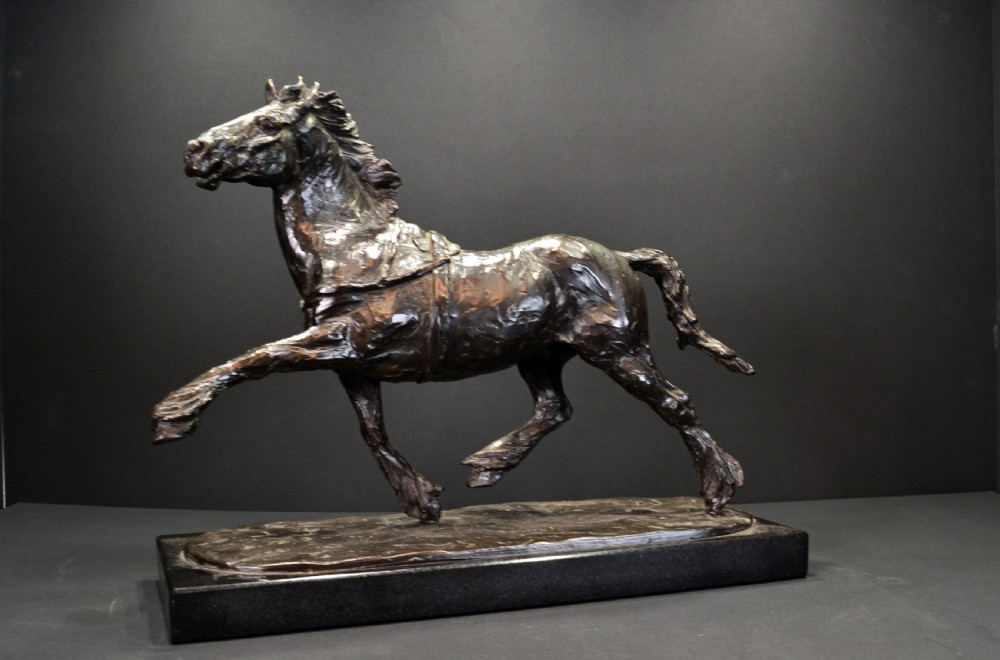 A dark bronze sculpture of a trotting cob horse mounted on a rectangular black stone base. View III