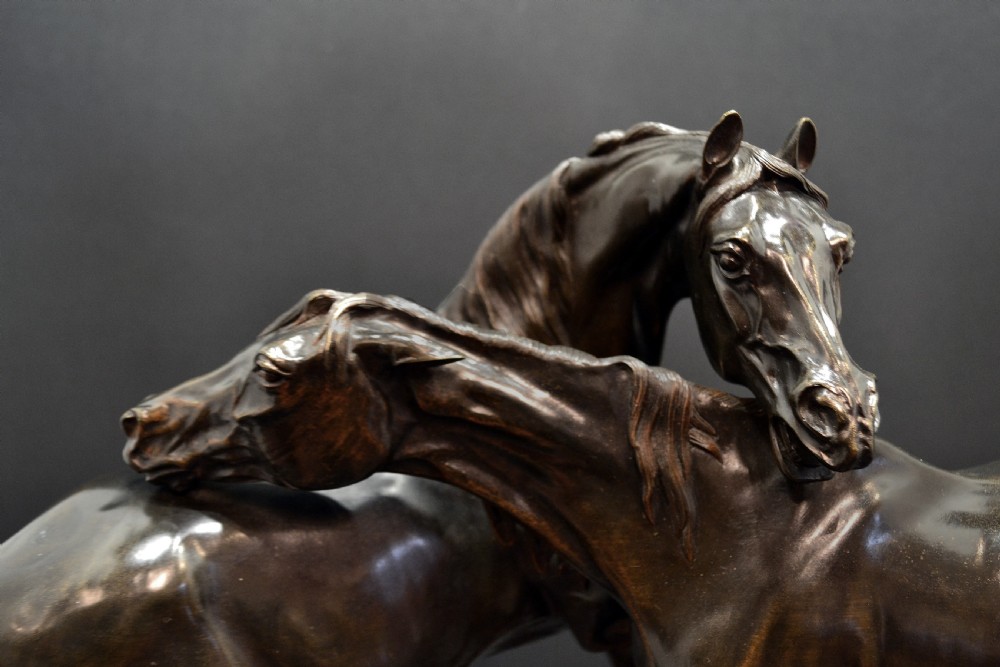 A dark brown bronze equestrian sculpture depicting an Arabian stallion and mare interacting on an oval naturalistic base. View II