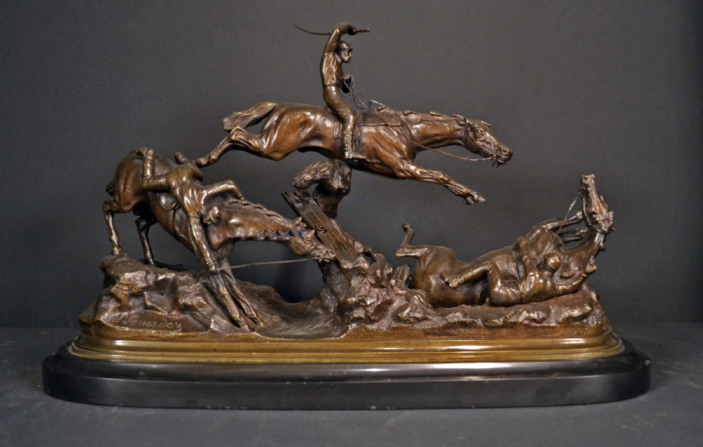 A patinated dark brown bronze sculpture depicting three steeplechase horses and jockeys jumping over a fence, mounted on a dark oval base.