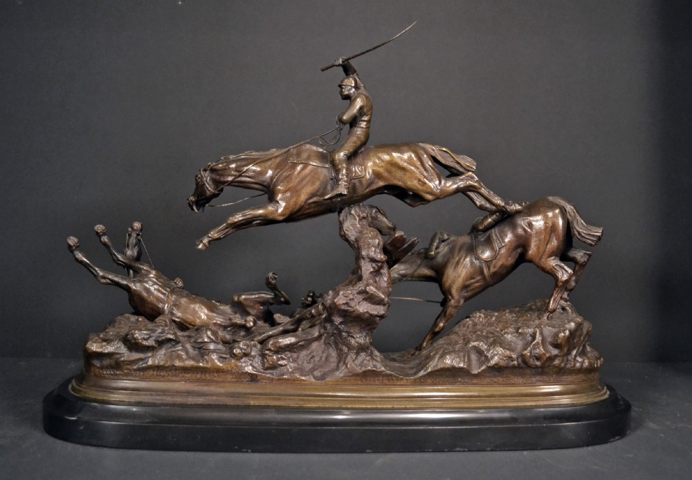 A patinated dark brown bronze sculpture depicting three steeplechase horses and jockeys jumping over a fence, mounted on a dark oval base. View II