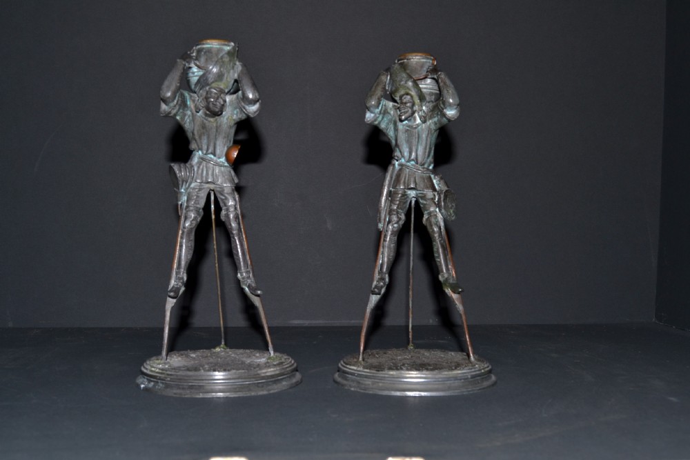 A fabulous Pair of bronze patinated spelter candlesticks in the form of Medievil characters on stilts. 