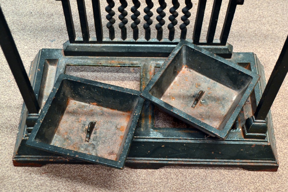 A black cast iron stick stand featuring a central relief figure of a nineteenth-century footballer holding a ball, framed by scrolling detail and twin drip trays. View IV