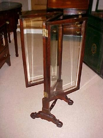 AN EDWARDIAN MAHOGANY THREE PANE FOLD OUT GLASS SCREEN