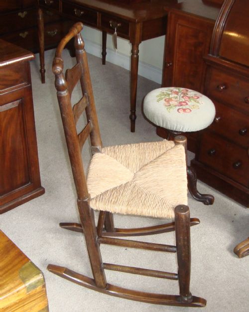 Georgian Oak Ladder Back Rocking Chair with Rush Seat.
